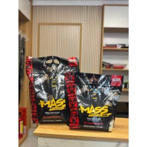 Mutant Mass extreme mass gainer powder in a black and green tub, a large scoop pouring creamy chocolate powder into a shaker bottle – 1,100 calorie weight gainer with 56g protein, 192g carbs, creatine, and BCAAs for massive muscle growth and strength gains.