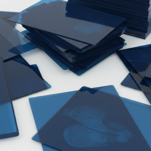 Stack of used medical X-ray films and industrial NDT films with dark images, ready for silver recovery